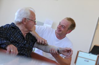Pfleger verbindet Patient den Arm