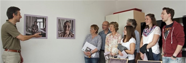 Ausstellung Menschen im Blick - Unterwegs mit der Caritas in Russland Ottmar Steffan erläutert bei der Ausstellungseröffnung, wie die Bilder in den Projekten der Caritas in Russland entstanden sind.